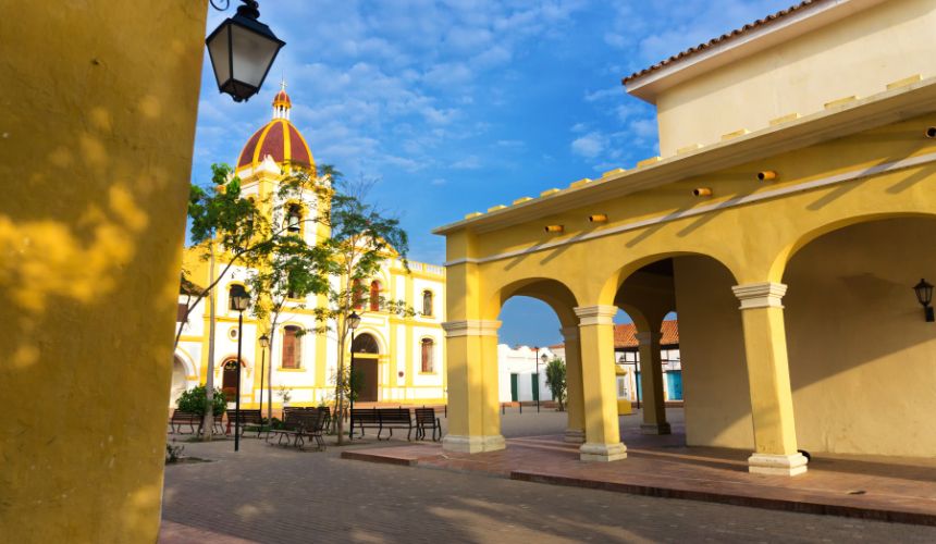 Unwind as you stroll past yellow colonial buildings with archways, basking under a blue sky beside a historic church. Experience Caribbean Renewal and let the vibrant colors and serene atmosphere rejuvenate your spirit.