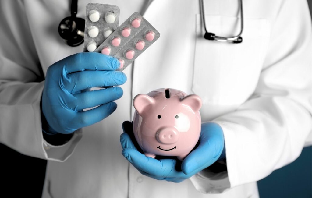 A doctor in a white coat and blue gloves holds a pink piggy bank and two blister packs of pills, illustrating the financial pros and cons of medical services, possibly hinting at medical tourism options in appealing destinations like Panama.