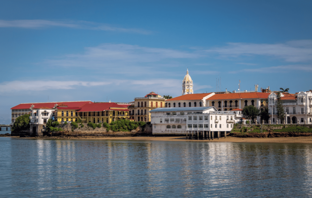 Historic buildings with red and white facades line the waterfront under a clear blue sky, capturing the charm of Panama. This vibrant scene is just a glimpse of what awaits visitors drawn to this destination, not just for its beauty but also for its growing reputation in medical tourism.