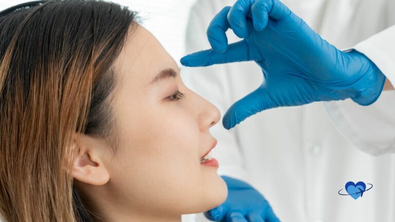 A person with long hair, eyes closed, is being examined by a doctor in blue gloves, likely discussing the details of a rhinoplasty procedure.